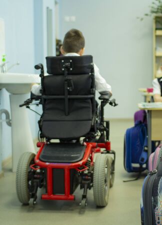 A disabled student in a wheelchair in primary school. Socialization of the individual in society.の写真素材