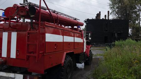 A fire truck at a burned-out wooden house .の写真素材