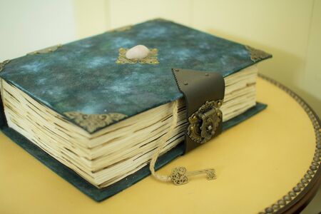 Vintage book with a key on a wooden background in classic blue color, as a concept of historyの写真素材