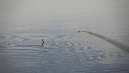 Fishing with a float rod on the waterの写真素材