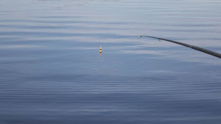 Fishing with a float rod on the waterの写真素材