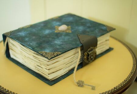 Vintage book with a key on a wooden background in classic blue color, as a concept of historyの写真素材