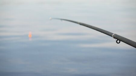 Fishing with a float rod on the waterの写真素材