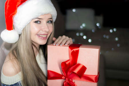 Beautiful blonde in a new years image with a gift box in her hands.