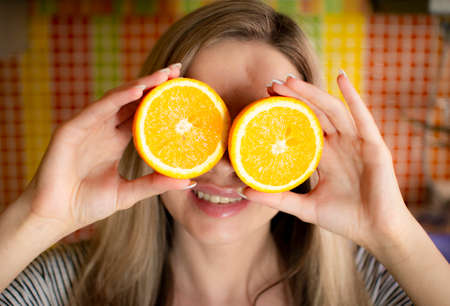 Portrait of a beautiful girl with orange slices in her hands .の写真素材