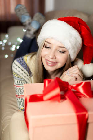Beautiful blonde in a new years image with a gift box in her hands.の写真素材