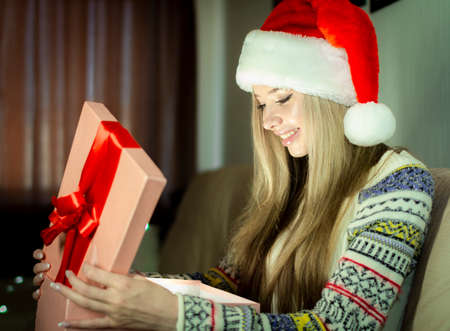 Beautiful blonde in a new years image with a gift box in her hands.の写真素材
