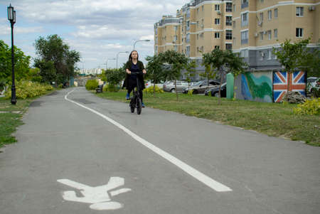 A young woman rides an electric Bicycle through the city.の写真素材