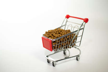 Shopping basket on a white background filled with cat food.の写真素材