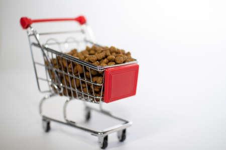 Shopping basket on a white background filled with cat food.の写真素材