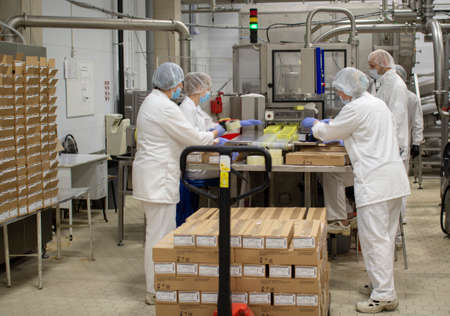 Vologda. Russia-July 2020: factory workers pack oil in a box. The process of packaging oil for...