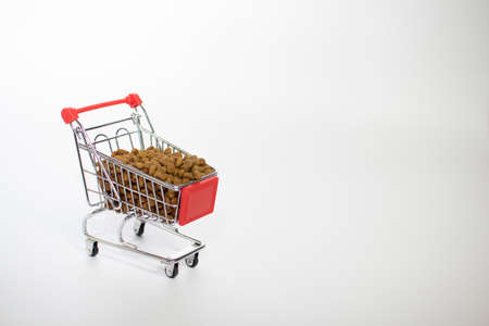 Shopping basket on a white background filled with cat food.の写真素材