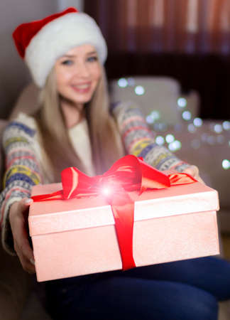 Beautiful blonde in a new years image with a gift box in her hands.の写真素材