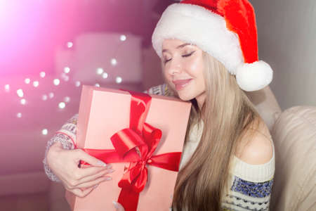Beautiful blonde in a new years image with a gift box in her hands.の写真素材