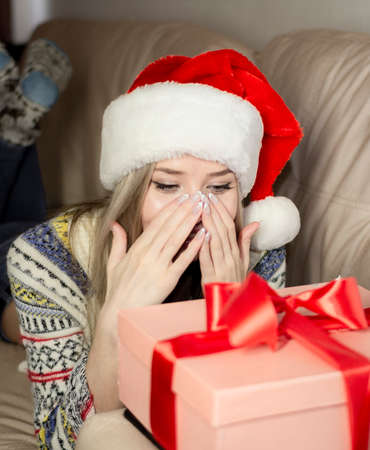Beautiful blonde in a new years image with a gift box in her hands.の写真素材