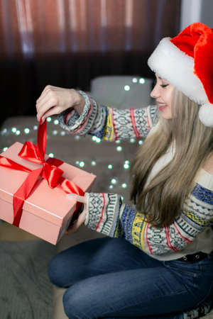 Beautiful blonde in a new years image with a gift box in her hands.の写真素材