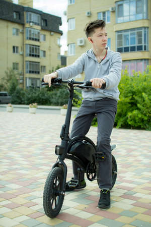 A teenager rides around the city on an electric bike.の写真素材