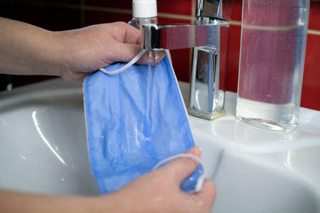 Washing a medical mask in the sink. Cotton reusable medical mask for protection from Covid-19.の写真素材