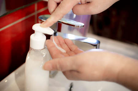 Woman washing her hand with liquid soapの写真素材
