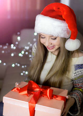Beautiful blonde in a new years image with a gift box in her hands.の写真素材