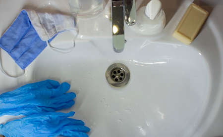 Washing a medical mask in the sink. Cotton reusable medical mask for protection from Covid-19.の写真素材
