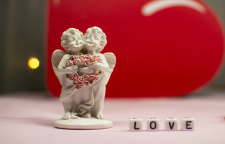 Two cute angels and the word love are made of ivory .Valentines Day. Postcard for the holidays.