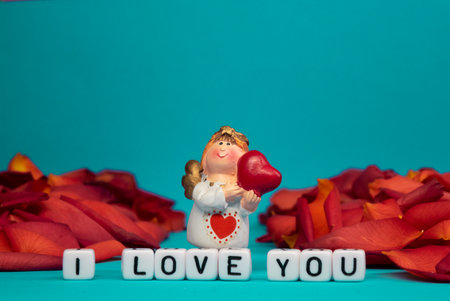 Cute angel and words of love on the background of rose petals .Valentines Day. Postcard for the holidays.の写真素材