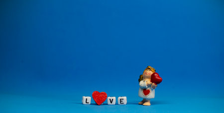 The charming angel and the word love are made of ivory .Valentines Day. Postcard for the holidays.の写真素材
