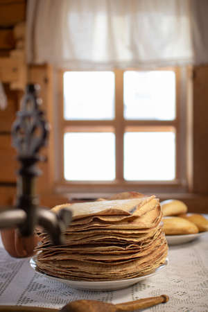 Pancakes in a wooden house on the background of a window.の写真素材