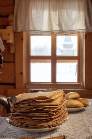 Pancakes in a wooden house on the background of a window.の写真素材