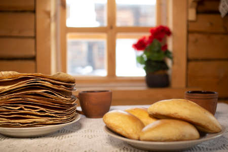 Pancakes in a wooden house on the background of a window.の写真素材