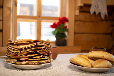 Pancakes in a wooden house on the background of a window.の写真素材