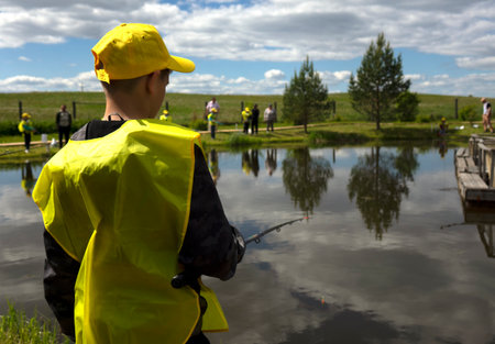 Fishing competitions among children. Fishermans Day at a fishing farm on July 14, 2020 in Ustye, Russia.のeditorial素材