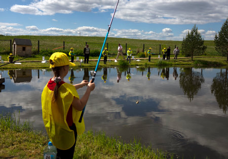 Fishing competitions among children. Fishermans Day at a fishing farm on July 14, 2020 in Ustye, Russia.のeditorial素材