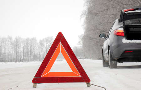 Emergency red sign on a snow-covered road.Car breakdown on the highway.の写真素材