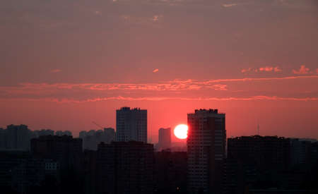 Sunrise over the city. The sun rises above the horizonの写真素材