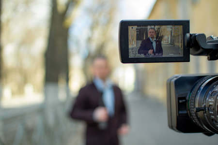 A middle-aged journalist is reporting in a deserted city.