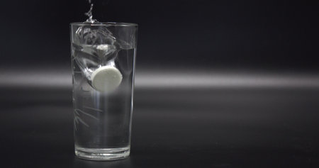 effervescent the tablet is thrown into a transparent glass beaker with water.の写真素材