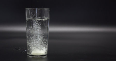effervescent the tablet is thrown into a transparent glass beaker with water.の写真素材