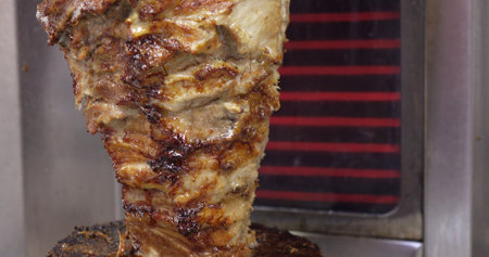 Meat on a spit . Cooking doner kebab or shawarma on a rotating vertical spit.の写真素材