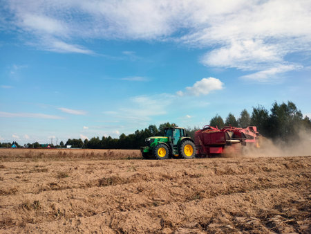 The tractor moves across the field and harvests potatoes. An agricultural machineの写真素材