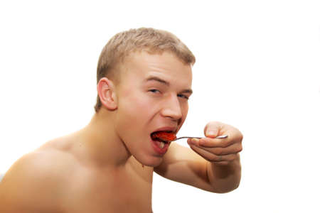 young man eating red caviarの写真素材