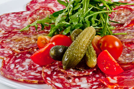 Italian sausage assorted with tomato, cucumber and ruccolaの写真素材