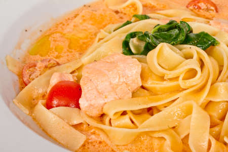 tasty pasta with cream, salmon, cheese and parsley close upの写真素材