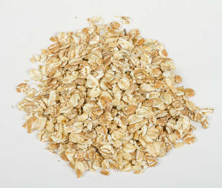 Heap of dry rolled oats isolated on white backgroundの写真素材