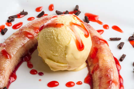 Bake banana with vanilla ice cream and caramel syrup; isolated on white with clipping pathの写真素材