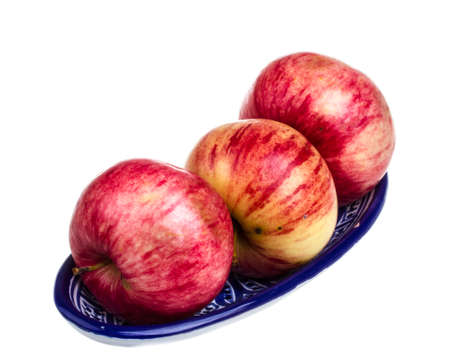 fresh red apples in the dish isolated on white backgroundの写真素材