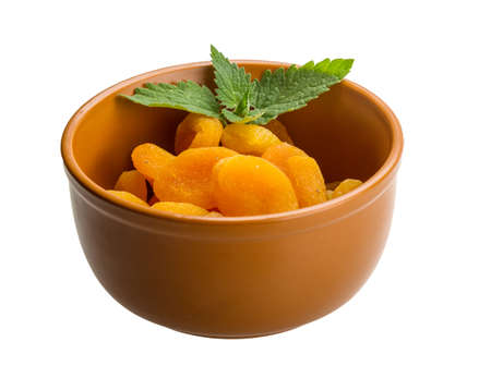 Dried apricots with melissa leaves isolated on white backgroundの写真素材