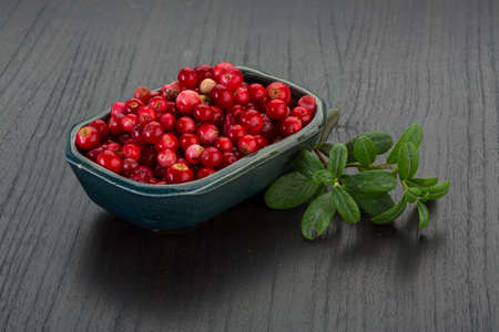 Cowberry in the bowl with leaves