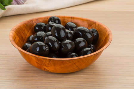 Black olives in the bowl on deskの写真素材